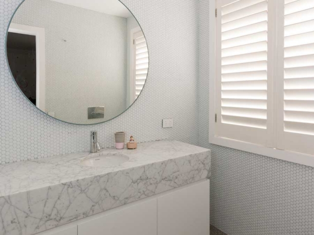 Photo of Glenn McGrath's new bathroom vanity featuring CDK Stone cararra marble benchtop, made by Benchmark Stonemasons, Sydney