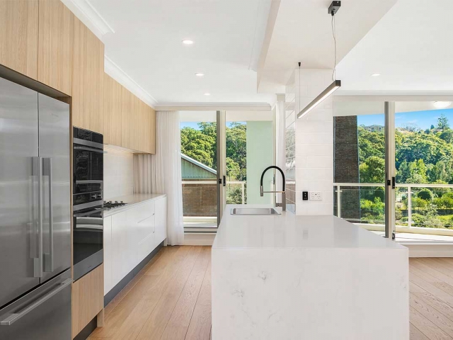 Smart Stone Cararra kitchen benchtop with waterfall edge. Unit renovation by Living Space Constructions.