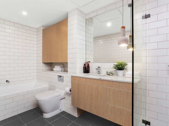 Bathroom vanity with natural calacatta marble top and undermount basin. Apartment renovation by Reno Pack.