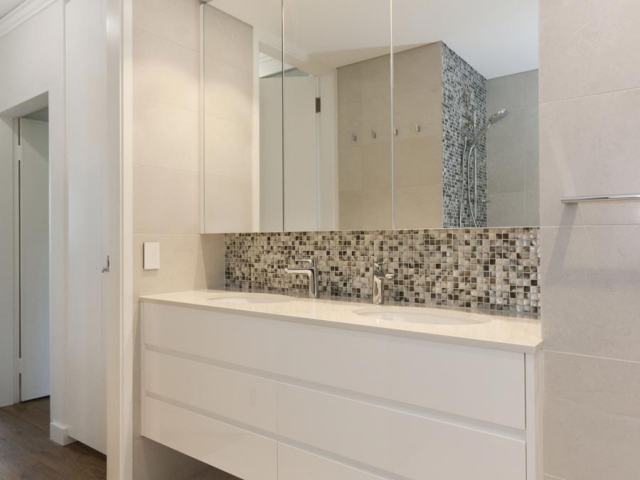 Custom made vanity with Quantum Quartz stone top in Carrara Quartz and double undermount basins. Bathroom renovation by Reno Pack featuring Caroma and Phoenix tapware and Villeroy and Boch toilet.