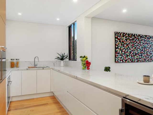 Quantum Quartz kitchen bench in Carrara Quartz. Apartment renovation by Reno Pack.