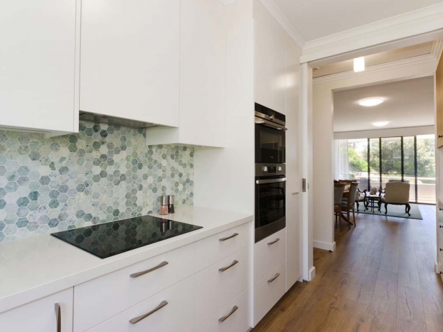 Quantum Quartz stone benchtop in Carrara Quartz. Kitchen renovation by Reno Pack featuring Dulux polyurethane cabinets, Westinghouse, Fisher Paykel appliances and Quick Step Impressive Ultra floating floor.