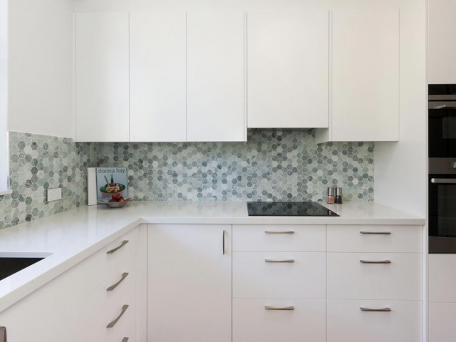 Quantum Quartz stone benchtop in Carrara Quartz. Apartment renovation by Reno Pack featuring Dulux polyurethane cabinets, Westinghouse, Fisher Paykel appliances and Quick Step floating floor.